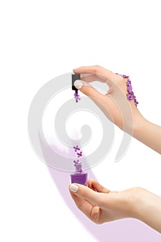 Female hand holding purple nail polish bottle. Spring concept