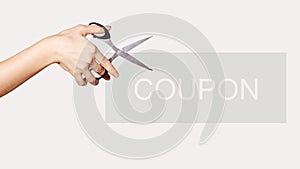 Female Hand is Holding Scissors. Copy Space for your Text. Isolated on White Background. Coupon for Shopping Sales
