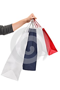 Female hand holding shopping bags isolated on white background