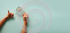 Female hand holding sieve flour on blue background. Baking and cooking concept. Banner with copy space