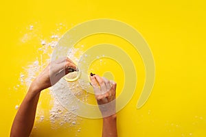 Female hand holding sieve flour on yellow background. Baking and cooking concept. Banner with copy space