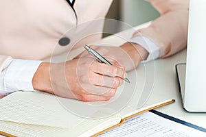 Female hand holding silver pen closeup
