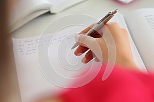 Female hand holding silver pen closeup