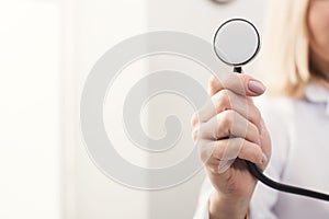 Female hand holding stethoscope closeup