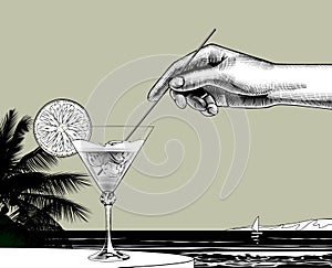 Female hand holding a straw dipped in a cocktail with a orange slice