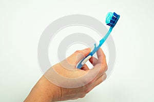 Female hand holding a toothbrush with toothpaste isolated on a white background.