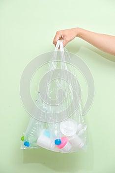 Female hand holding a waste bag  on white background