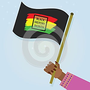 Female hand holding waving Black History Month flag with on blue gradient background