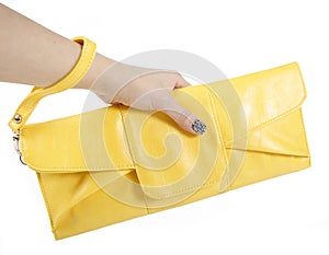 Female hand holding yellow clutch bag