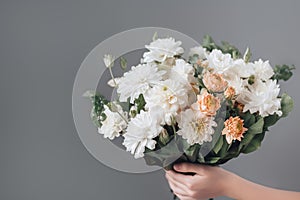 Female hand holds beautiful bouquet of chrysanthemums. Mothers day, holiday decor, Flower delivery concept. Generative
