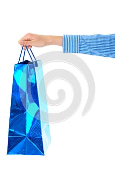 Female hand holds blue gift bag, isolated