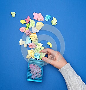 Female hand holds crumpled multi-colored pieces of paper