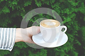 Female hand holds a cup of coffee