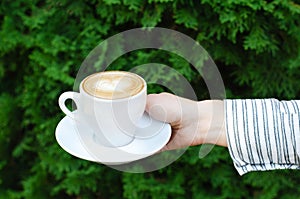 Female hand holds a cup of coffee