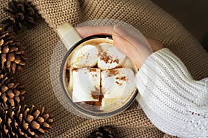 Female hand holds cup of hot chocolate with marshmellows, christmas holiday winter composition