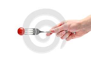 Female hand holds a dining fork with fresh cherry tomatoes isolated on the white background