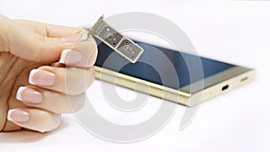 a female hand holds a dual SIM card slot.