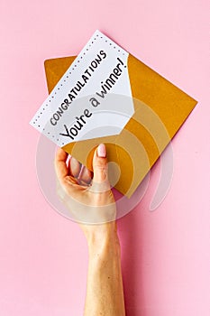 Female hand holds envelope with card You are a winner. Congratulations award letter