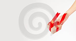 Female hand holds a gift box on a white background. Holiday and shopping concept. Christmas, Valentine`s Day, Mother`s Day, Wome