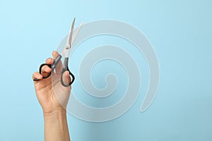 Female hand holds hairdresser scissors on background