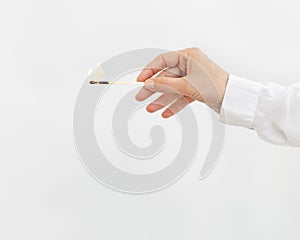 Female hand holds lit match. Wooden matchstick with fire. Fire Hazard concept