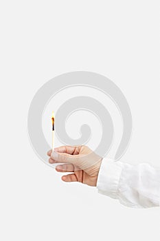 Female hand holds lit match. Wooden matchstick with fire. Fire Hazard concept.