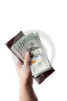 Female hand holds opened brown wallet with a thick wad of new one hundred dollar bills. isolated over a white background. vertical