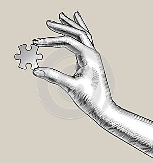 Female hand holds a puzzle in her fingers