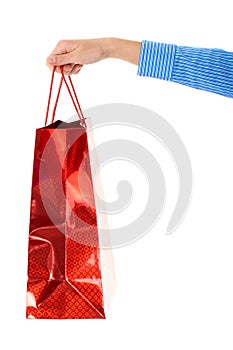 Female hand holds red gift bag, isolated