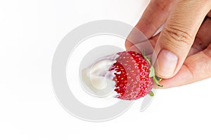 female hand holds a strawberry berry with cream. juicy, sweet, ripe, red strawberries on a white background. isolate