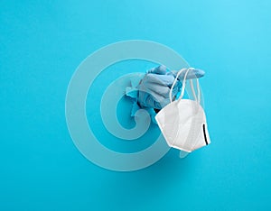 Female hand holds a white disposable medical mask to protect against viruses during an epidemic and pandemic. Part of the body