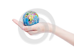 Female hand holds world globe on white background.