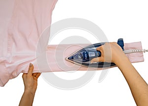 Female hand ironing clothes top view isolated on white background. Young woman with iron ironing man`s shirt seen from above