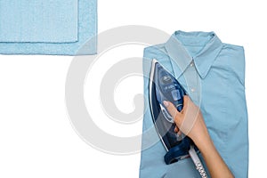 Female hand ironing clothes top view isolated on white background. Young woman with iron ironing mans shirt seen