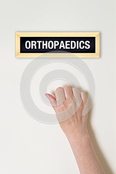 Female hand is knocking on Orthopaedic door