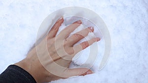 Female hand leaves an imprint in a snowdrift of snow.