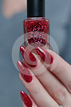 Female hand with long nails and a bright red manicure