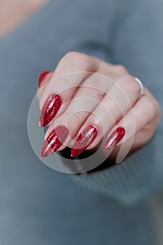 Female hand with long nails and a bright red manicure