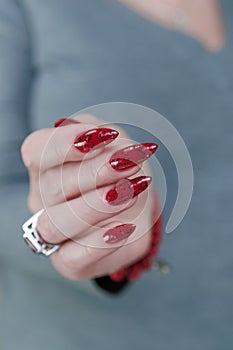 Female hand with long nails and a bright red manicure