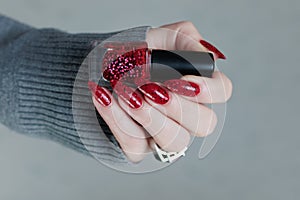 Female hand with long nails and a bright red manicure