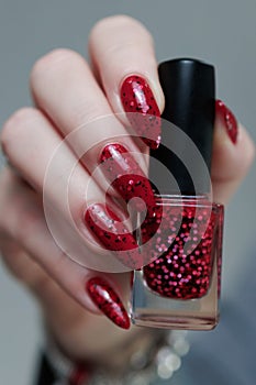 Female hand with long nails and a bright red manicure