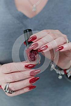 Female hand with long nails and a bright red manicure