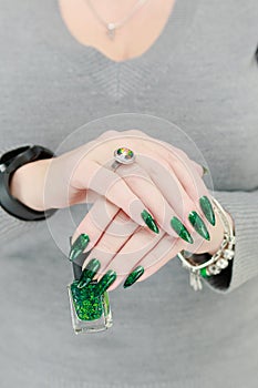 Female hand with long nails and green manicure