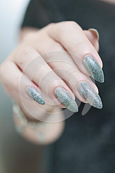Female hand with long nails and a white gray silver manicure