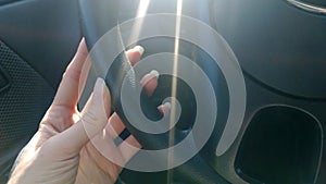 Female hand with long natural nails incorrectly holding the wheel of a car.