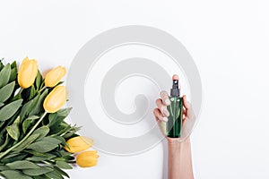 Female hand with manicure holds a green plastic bottle of water