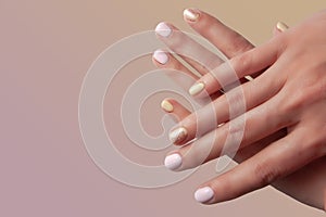 Female hand with manicure on pink background