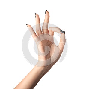 Female hand with manicure showing OK gesture on white background