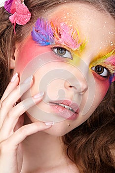 Female with hand near face and fashion feather eyelashes make-up