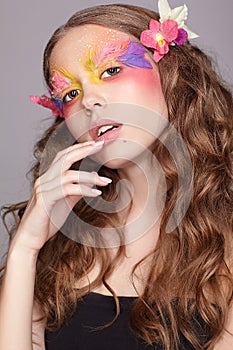 Female with hand near face and fashion feather eyelashes make-up